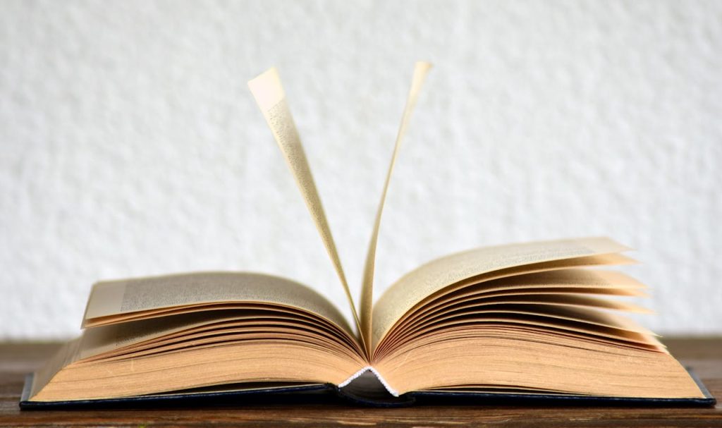 pexels photo 415071 Close-up image of an open book with pages turning, creating a dynamic visual.